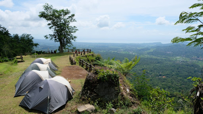 2. Paket Wisata Kemah Bukit Nampo Masih di kabupaten yang sama, Bukit Nampo. Bukit Nampo atau yang dapat disebut juga dengan Bukit Surga ini dapat menjadi alternatif kalian jika ingin berkemah di Kabupaten Karangasem. Pemandangan yang memukau seperti yang kami telah sampaikan sebelumnya akan membuat kalian para Travelers dan Campers akan merasa nyaman ketika berkemah disini. Seperti Bukit Asah, Bukit Nampo juga menyediakan paket-paket wisata berkemah yang terdiri dari empat paket diantaranya adalah paket camping backpacker, paket camping mahasiswa, paket camping standard, dan paket camping deluxe. a. Paket Camping Backpacker – Rp.100.000 Fasilitas: tiket masuk, toilet, listrik, wifi, dan kebersihan. Harga tersebut belum termasuk tenda yang dapat dibawa sendiri. b. Paket Camping Mahasiswa – RP.175.000 Fasilitas: Tenda dengan kapasitas 4 orang, matras yoga, tiket masuk, toilet, listrik, wifi, dan kebersihan. c. Paket Camping Standard – mulai dari Rp.200.000 - Rp.250.000 Paket Camping Standard dengan biaya Rp.200.000 sudah termasuk 2 orang, untuk biaya Rp.225.000 sudah termasuk 3 orang, dan biaya Rp.250.000 sudah termasuk 4 orang. Fasilitas: tenda, matras, sleeping bag, bantal, tiketmasuk, toilet, listrik, wifi, kebersihan, dan masih banyak lagi. d. Paket Camping Deluxe – mulai dari Rp.300.000 - Rp.350.000 Paket Camping Standard dengan biaya Rp.300.000/2 orang, untuk biaya Rp.325.000/3 orang, dan biaya RP.350.000/4 orang. Fasilitas: Tenda, bed, sleeping bag, bantal, tiket masuk, toilet, listrik, wifi, dan kebersihan. Sebagai informasi tambahan, Bukit Nampo juga menyediakan layanan tempat sewa peralatan dan perlengkapan Camping, lho. Jadi kalian tidak perlu khawatir jika nantinya ada yang tertinggal atau kurang. Perlengkapan tersebut diantaranya adalah tenda, matras kecil, matras jumbo, sleeping bag, bed, bantal kecil, bantal besar, lampu dalam, kayu bakar, sabut kelapa, beras, nasi bungkus, ayam siap panggan, dan masih banyak yang lainnya.